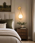 Lit Mid Century Modern Wall Sconces Set Of 2 With Globe Glass Shades In Antique Brass Finish in bedroom setting