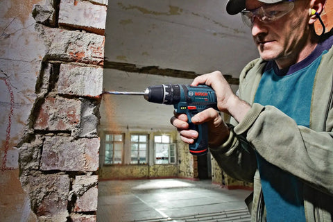 Man using 12-Volt Max Cordless Drill And Impact Driver Combo Kit CLPK241-120 Ultra Compact And Lightweight on brick wall