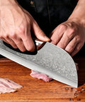 Person using 2 Piece Beast Mode Meat Cleaver Knife Set for Effortless Chopping on wooden board, Viking style carbon steel blade.