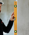 4pcs Acrylic Cylindrical Mini Spirit Level Tool for Precise Measuring used by a worker to check wall level with a yellow level.