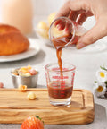 Pouring liquid into Two Pack Shot Glass Measuring Cup Set With Thick Base, Multi Unit Liquid Measuring Cup For Espresso And Drinks, Four Measuring Scales Include 1 OZ, 2 TBS, 6 TSP, 30 ML For Precise Pouring