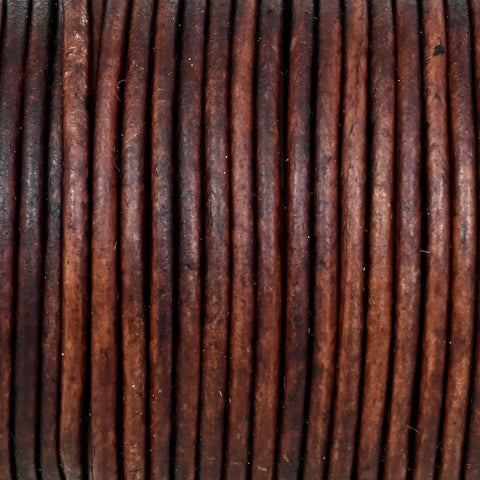 Genuine Round Leather String Cord One Point Five Mm Long Distressed Antique Brown soft twine coiled in a neat bundle.