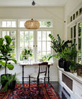 Boho Pendant Light With Plug In Cord And LED Bulb Dimmer Switch 15 Foot Hanging Wicker Rattan Chandelier in plant-filled room.