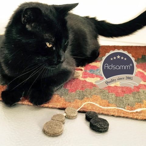 Black cat lying on a colorful rug near Hella Durable Self Adhesive Felt Pads Black Round Furniture Glides.