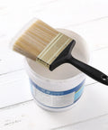 4 Inch Soft Tip Paint Brush For Walls And Trim With Pro Grade Synthetic Bristles next to a paint can on a wooden surface