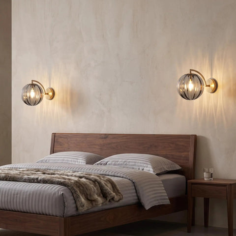 Mid‑Century Modern Globe Glass Wall Sconce with Wine Red Hand‑Blown Glass illuminating a stylish bedroom wall.