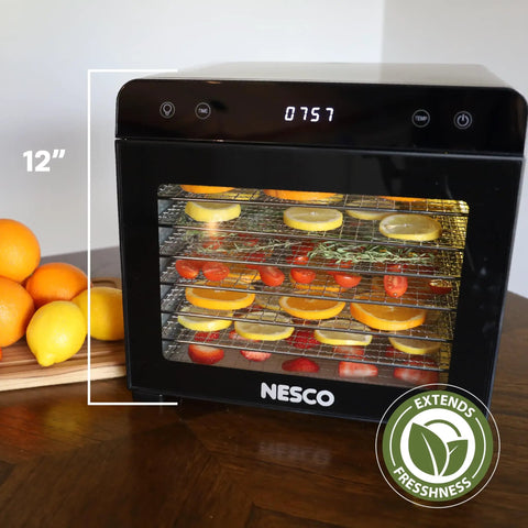 Top Shelf Eight Tray Stainless Steel Food Dehydrator Running Smooth With Digital Timer And Adjustable Temp Control Made For Killer Jerky Dried Fruits Veggies Fresh Herbs Dog Biscuits 650W Bpa Free showing oranges and herbs on trays.