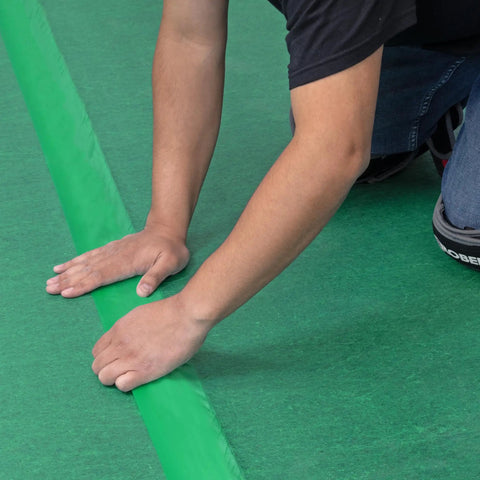 Person installing Straight Up Heavy Duty Underlayment Pad For Laminate And Engineered Wood Floors Featuring Gnarly Moisture Shield.