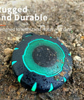 Waterproof Shower Bluetooth Speaker With IPX7 Rating, Ultra Portable Carabiner Clip on muddy ground emphasizing durability.