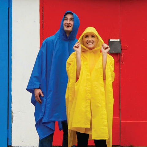 Adult Lightweight Hooded Packable Poncho With Side Snaps For All Weather Protection, Go To Rain Gear That Packs Into Its Own Pouch, Maximum Coverage When You Need It displayed on two people, one in yellow poncho and one in blue poncho against a colorful background with red door.