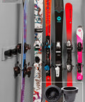 Badass Five Pack Ski Wall Hangers securely grip skis of various styles mounted on a wall, showcasing sturdy plastic construction.