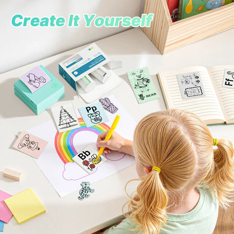 Portable Mini Sticker Printer With Three Thermal Rolls Compact Wireless Label Maker For Teachers And Craft Crews at a colorful crafting table.