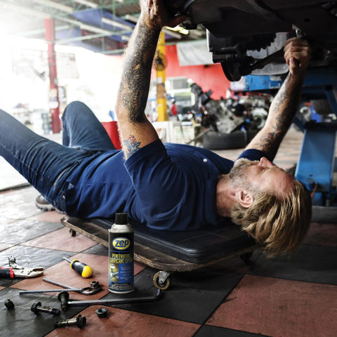 Mechanic using Industrial Strength Penetrating Lubricant Spray For Bolts Screws Nuts And Locks 12 Oz Case Of 12 on vehicle