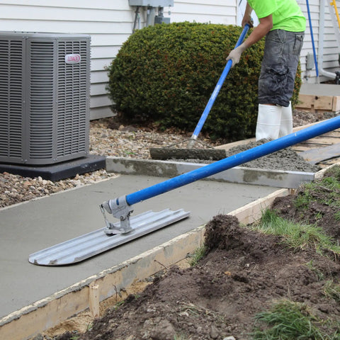 Rock It Bull Float Bracket For Concrete With Easy Half Turn Pitch Control in use on a wet concrete slab, blue handle visible.