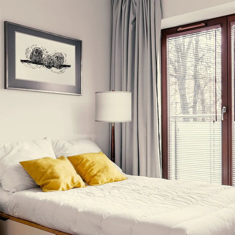 Lucas LED Floor Lamp With Drum Shade And Warm Wood Finish beside bed in modern bedroom with yellow cushions.