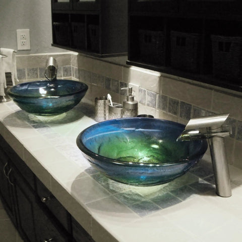 Thick Round Glass Vessel Bathroom Sink With Blue Yellow Green Swirl Dope Look Stylish Modern Three Quarter Inch Tempered Glass Scratch Resistant And Non Porous Above Counter Mount 16.5 Inch Wide By 5.75 Inch Tall Standard 1.75 Inch Drain Opening shown installed on counter