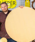 Man holding large wooden disc made with Blemish Free Pivot Plate For Circle Cutting No Center Hole Required For Flawless Discs And Tabletops Clean Edges Easy Router Jig Accessory Works With All Circle Cut Guides For Top Notch Results, standing in workshop with Jasper Tools background.
