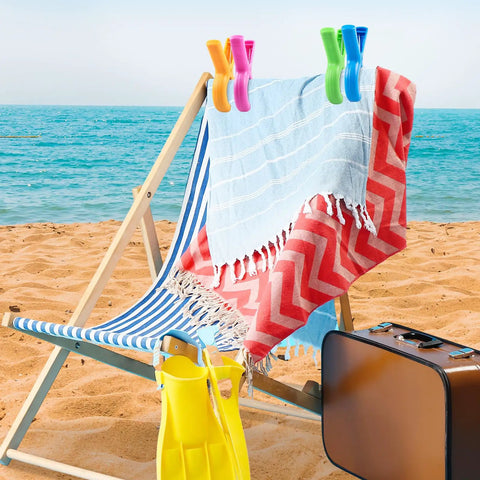 Heavy Duty Beach Towel Clips Eight Pack For Beach Chairs And Pool Loungers Jumbo Size With Strong Grip holding towels on a chair by the sea