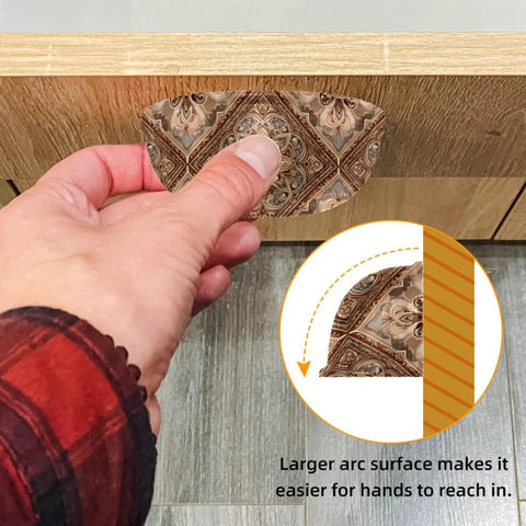 Close-up of a hand pulling a drawer with a Vintage Shell Shaped Drawer Pull 3.4 Inch with rustic ethnic pattern on wooden surface.