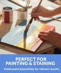 Baltic birch plywood craft board being painted with blue, yellow, and red strokes; paint cans and brushes visible.