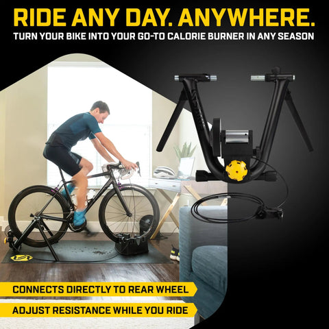 Cyclist using Magnetic Plus Indoor Bike Trainer With Wheel On Setup And Quiet Fluid Resistance For Realistic Rides No Wheel Removal Needed Linear Resistance That Matches Each Pedal Stroke And Gear Plus Easy Zwift App Connectivity For Home Gym Training in a living room