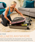 Woman packing HexaPlate Lite Vibration Plate For Full Body Toning And Recovery With Lymphatic Drainage Compact Vibe Platform into suitcase