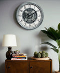 Large 15 Inch Moving Gears Wall Clock In Sleek Silver, Industrial Steampunk Vintage Decor With Bold Numbers on a wall.