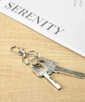 Badass Swivel Snap Hooks And D Rings Set Keychain Clips Lobster Claw Clasps attached to keys on a wooden table.