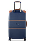 Delsey 26-inch spinner luggage in navy blue with faux leather accents, featuring a sturdy polycarbonate shell and spinner wheels for easy travel.