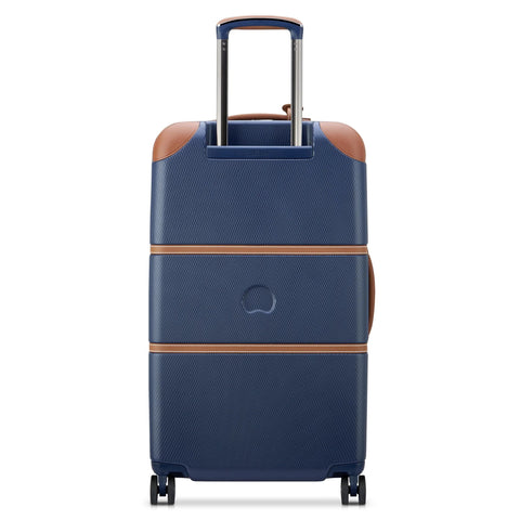 Delsey 26-inch spinner luggage in navy blue with faux leather accents, featuring a sturdy polycarbonate shell and spinner wheels for easy travel.