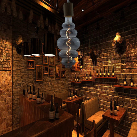 Beehive Style 4W Dimmable LED Edison Bulb With Oversized Spiral Filament, Smoky Grey Glass in cozy restaurant setting
