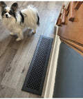 Beefy Heavy Duty Cast Aluminum Floor Air Grille For 6x30 Duct Opening With 8x32 Face Plate Matte Black Powder Coat Beveled Edges Quarter Inch Not For Wall Use installed on wooden floor next to small dog.