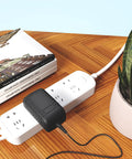 Heavy Duty 18V AC DC Power Adapter For Rotary Craft Tools With Smart Thermal Breaker connected to power strip on wooden table.