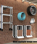 Beefy Heavy Duty 12.4 Inch Wall Mount Garage Hooks Set Of 4 holding ladder, hose, tire, chairs, and shovels on brick wall