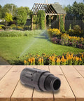 30 PSI drip irrigation pressure regulator for 3/4 inch garden hose on a wooden table, garden background, black plastic