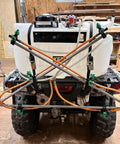 Six Nozzle Folding Sprayer Boom Delivers 122 Inch Coverage For ATV And UTV Sprayers, mounted on rear of ATV in workshop setting