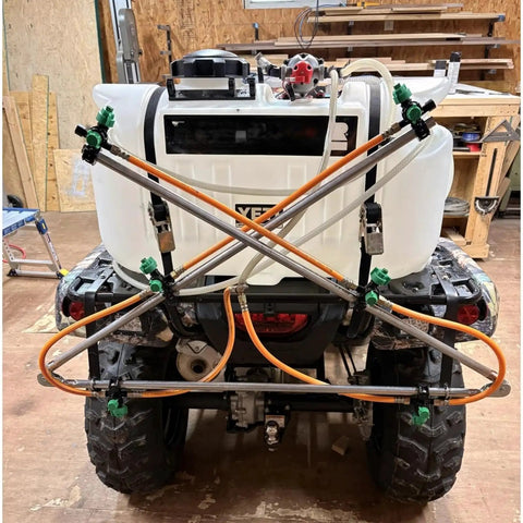 Six Nozzle Folding Sprayer Boom Delivers 122 Inch Coverage For ATV And UTV Sprayers, mounted on rear of ATV in workshop setting