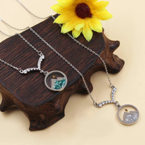 Faith Boost Mustard Seed Pendant Necklace for Women with V Shaped Stainless Steel Design and Cubic Zirconia Accents on display.