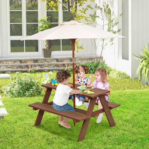 Outdoor Wooden Kids Picnic Table With Removable Umbrella Foldable Bench Set For Backyards And Patios Toddler Friendly Outdoor Furniture In Walnut Durable Safe Shade For Boys And Girls Great Gift with children playing in a backyard.
