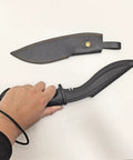 Hand holding a 12 inch Nepalese style tanto blade from Plastic Practice Knife Set, with PU sheath beside it.