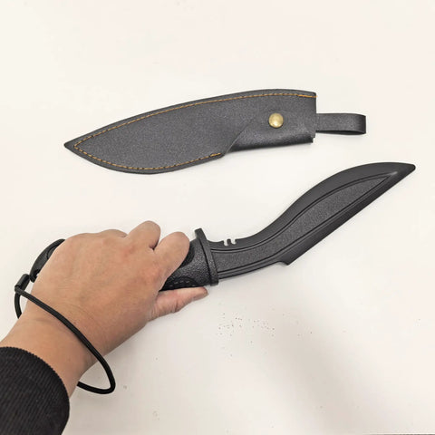 Hand holding a 12 inch Nepalese style tanto blade from Plastic Practice Knife Set, with PU sheath beside it.