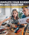 Father and daughter working on a science project with electronic components at a table, using instructions.
