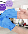A person wearing blue nitrile vinyl blend exam gloves, ambidextrous and non-sterile, demonstrating flexibility.