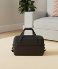 Underseat Carry On Duffle Bag 20L For Plane Travel, Gym, And Weekend Getaway, Compact 15.75 By 9.84 By 7.87 Inches in black on floor.