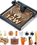 WIZMAKER 12W desktop laser engraver on gray frame with 300×300mm bed; wood panel featuring a tiger design.