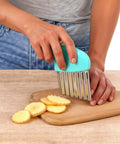 Side view of XLIUAX 2-pack crinkle cutter with teal handle and stainless wavy blade slicing potato rounds on wood board