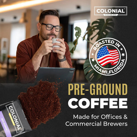Man enjoying a cup of Colombian Arabica Ground Coffee in an office setting with Pre-Ground Coffee pack visible