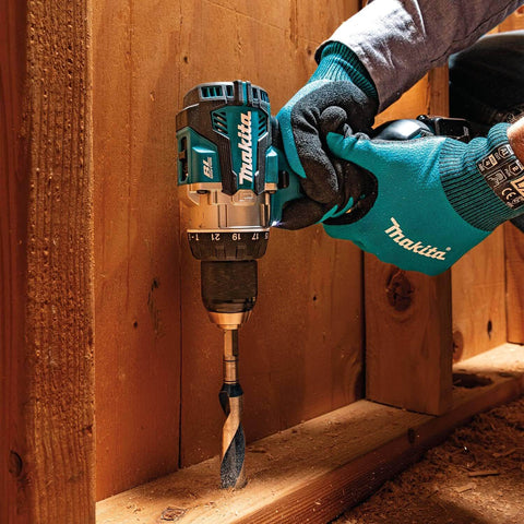 Person using 18V LXT Brushless Compact Hammer Drill Driver One Half Inch Cordless Tool Only, 970 Inch Pounds Max Torque, on wooden surface.