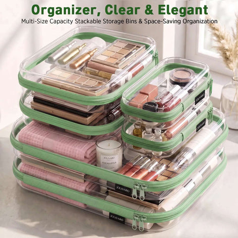 Clear Hard Shell Zipper Case And Mini Pouch Set To Keep Your Daily Stash Organized With Tough Rigid Construction And Slick Stackable Design For Hassle Free Travel Packing And Easy Access Without Ever Messing Up Bags. Stackable clear storage bins with green zippers, containing cosmetics and accessories.