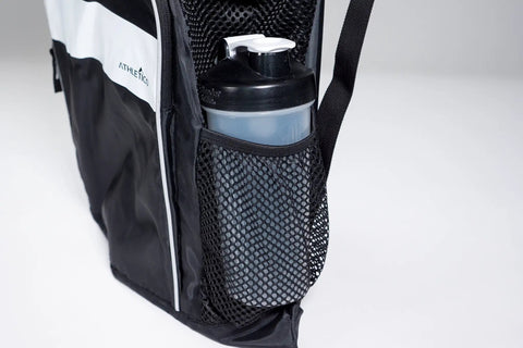 Close-up of a black mesh swim bag's side pocket holding a water bottle, showcasing the open weave quick dry material.
